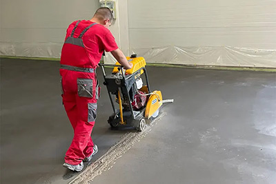 Radnik seče beton mašinom za rezanje betona